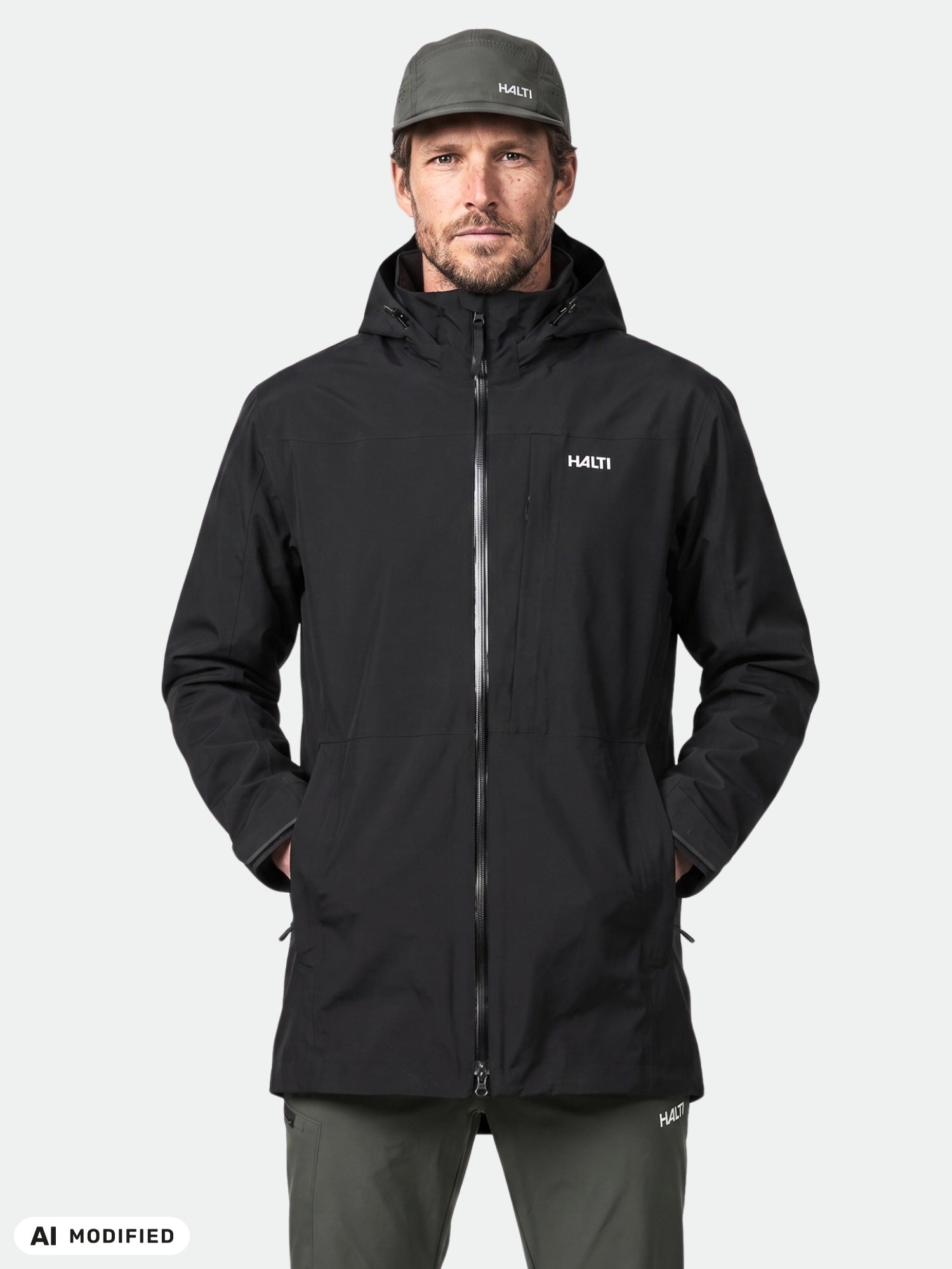 Man wears Halti Valaja DX Parka Jacket in black, hands in pockets, against a plain light background.