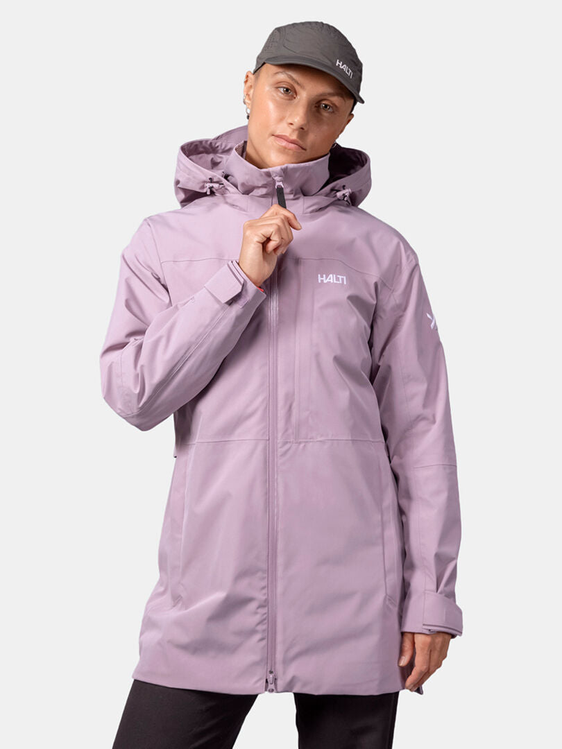 Person wearing a light purple Halti Valaja DX Parka Jacket (women's) and dark cap, standing against a plain light background.