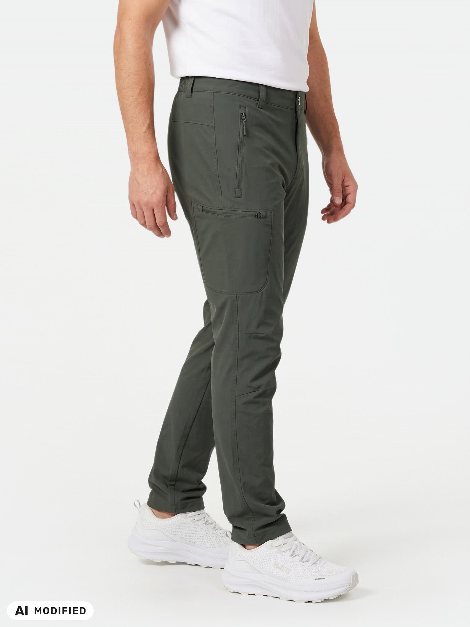 Wearing Halti Pallas X-stretch Outdoor Pants in dark green, a white tee, and sneakers, against a plain background.