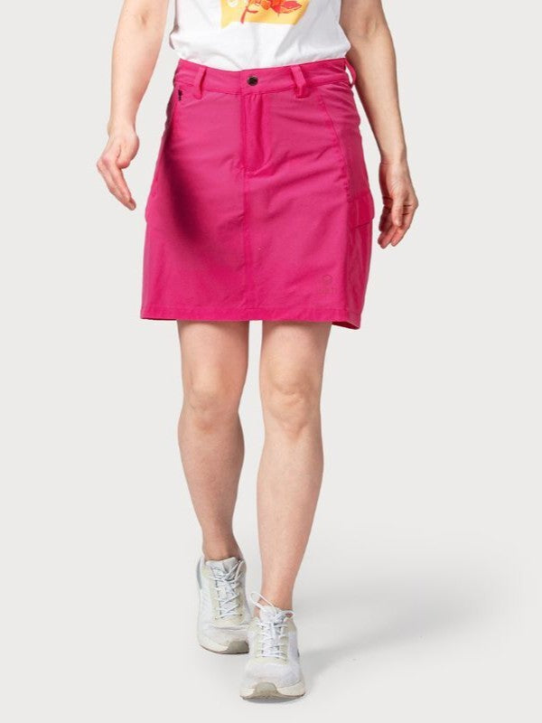 A person wears the Halti Reissu Stretch Skort for women, a white graphic tee, and sneakers against a plain background.