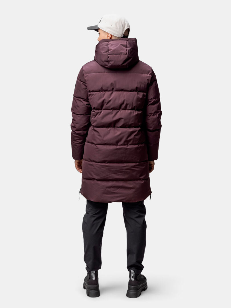 A woman in a Halti Linjat Parka Jacket, black pants, and gray cap, viewed from behind.