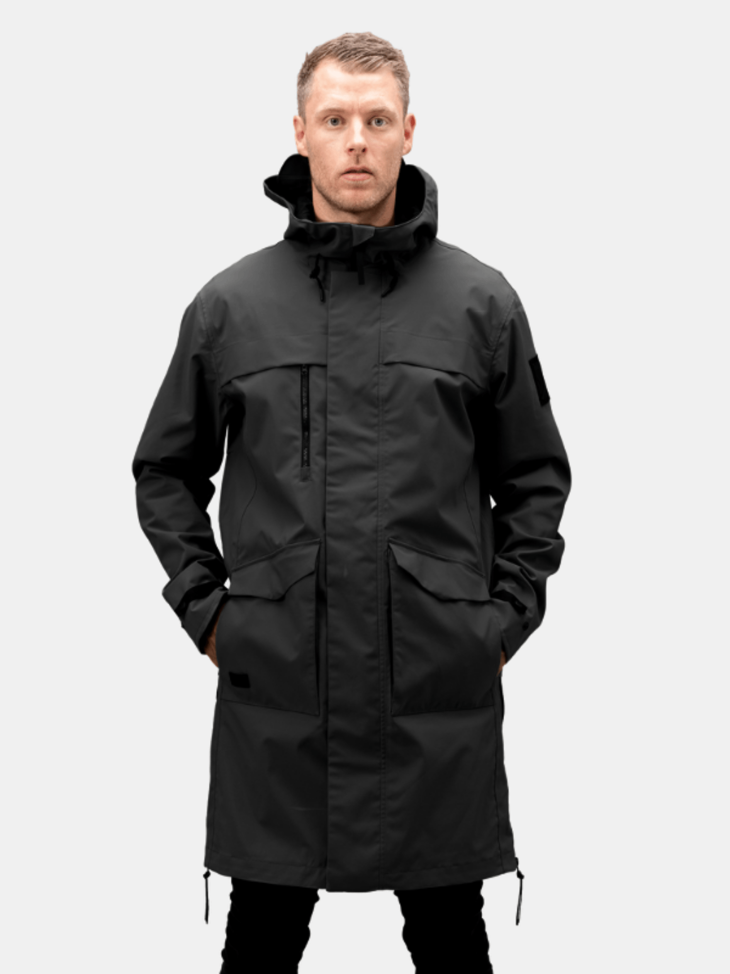 A man faces forward in a Halti Tokoi Mens DrymaxX Parka Jacket, hands in pockets, ready for urban conditions.