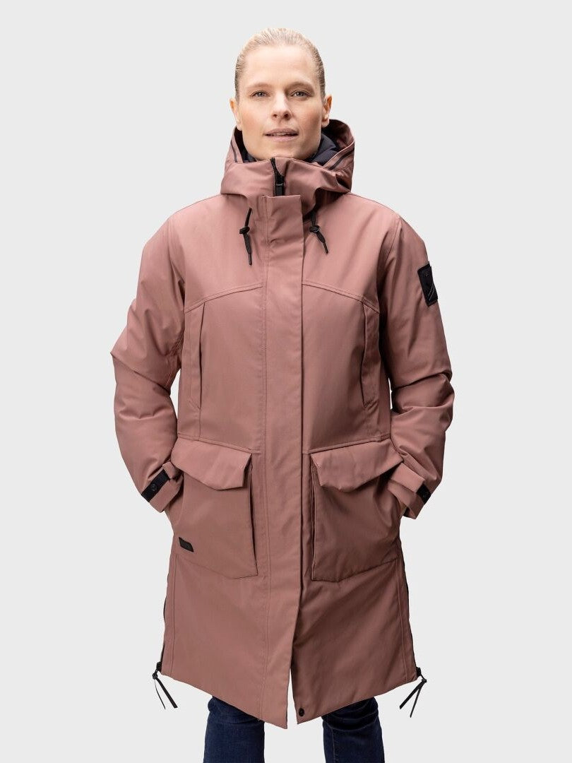A woman wears the Halti Bergga Women's DrymaxX Winter Parka with hood, front pockets, and black drawstrings.
