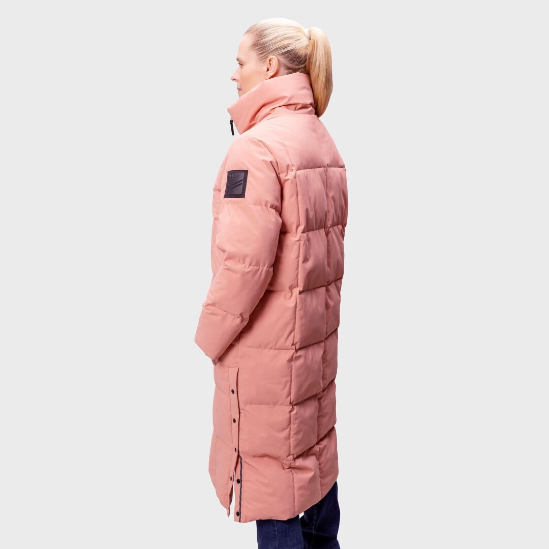 Woman wears Halti Penger Winter Jacket in pink with a high collar, DrymaxX® fabric, seen from the side.