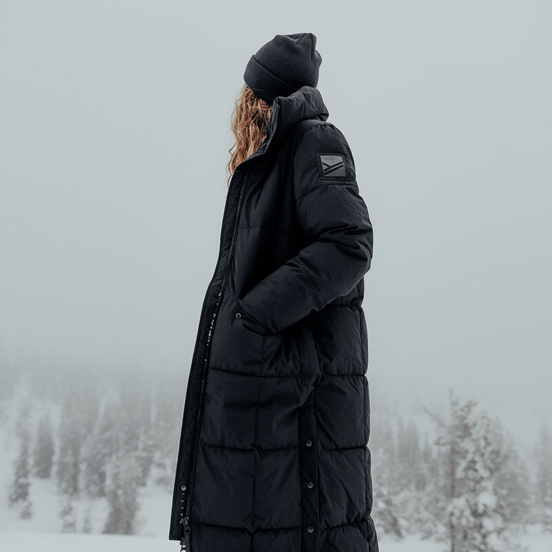 A person in a Halti Penger Winter Jacket Womens with DrymaxX® stands outdoors in a snowy, foggy forest.