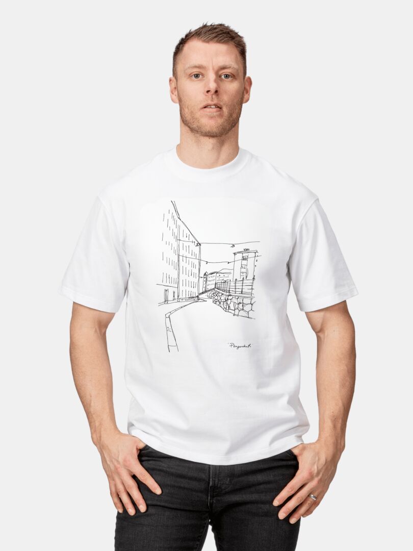 Man in oversized unisex Halti Skaltsi T-shirt in organic cotton with black city street art, against a plain background.