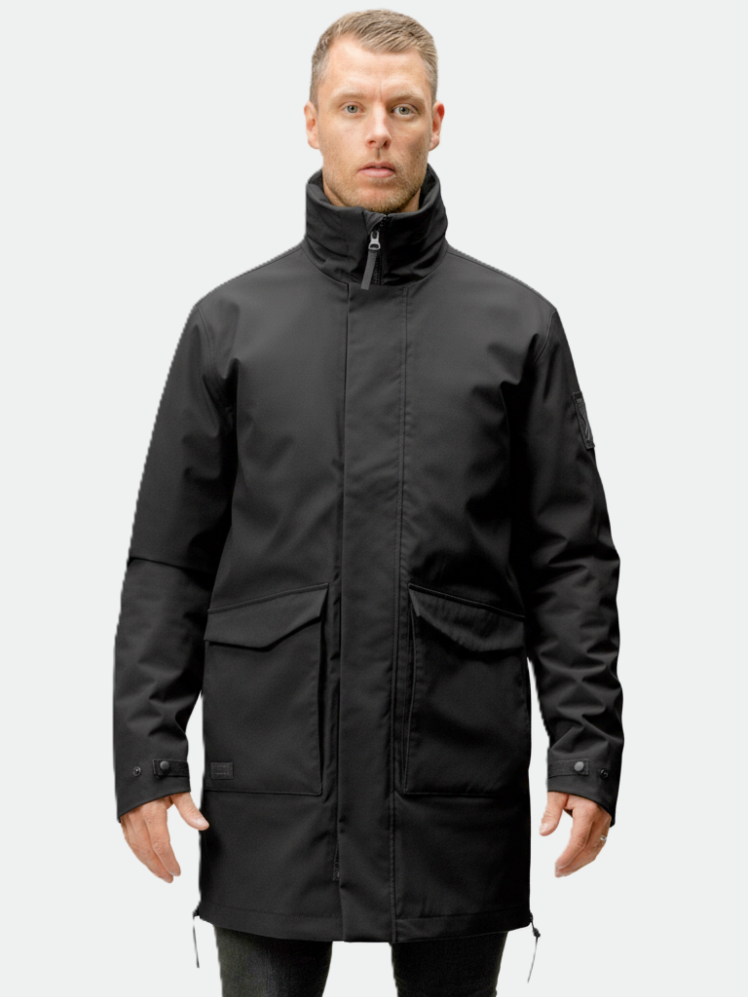 A man faces forward, wearing the Halti Synkas 3in1 DrymaxX Parka with a high collar and front flap pockets.