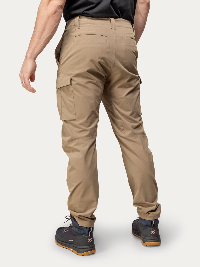 A person in Halti Roams Cargo Pants and black boots stands with their back to the camera against a plain background.