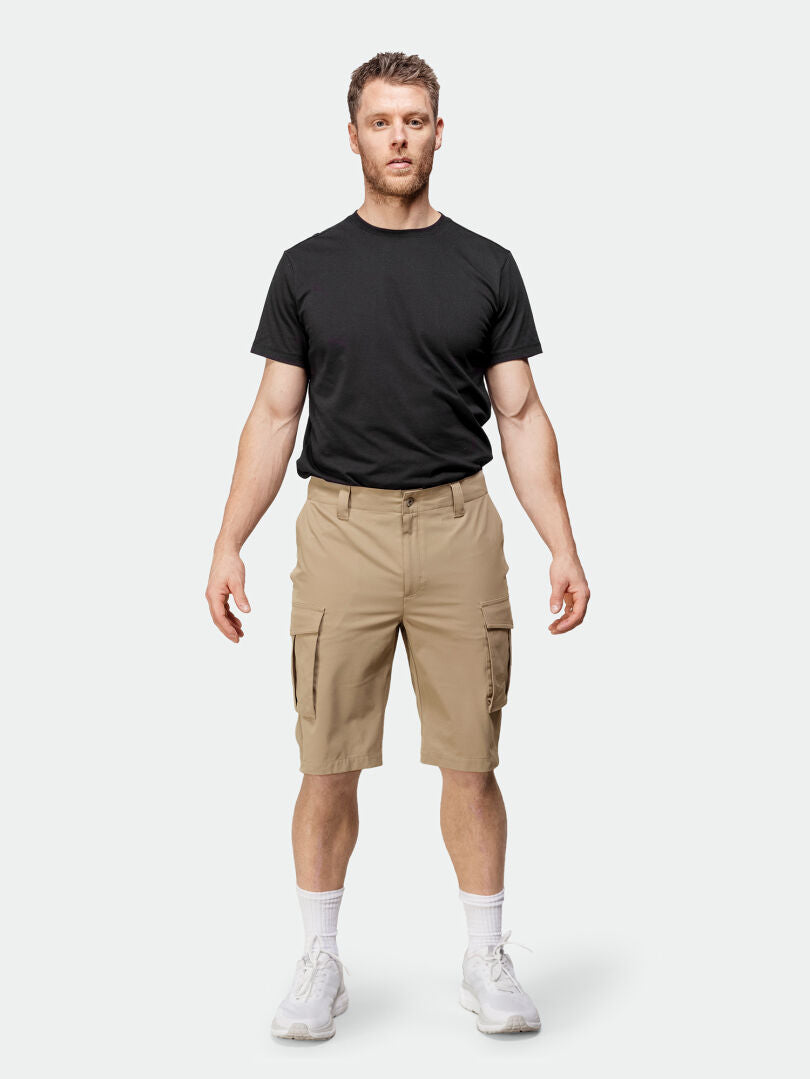 A man faces forward in a black tee and Halti Roams Shorts Mens in stretchy ripstop, with white socks and sneakers.