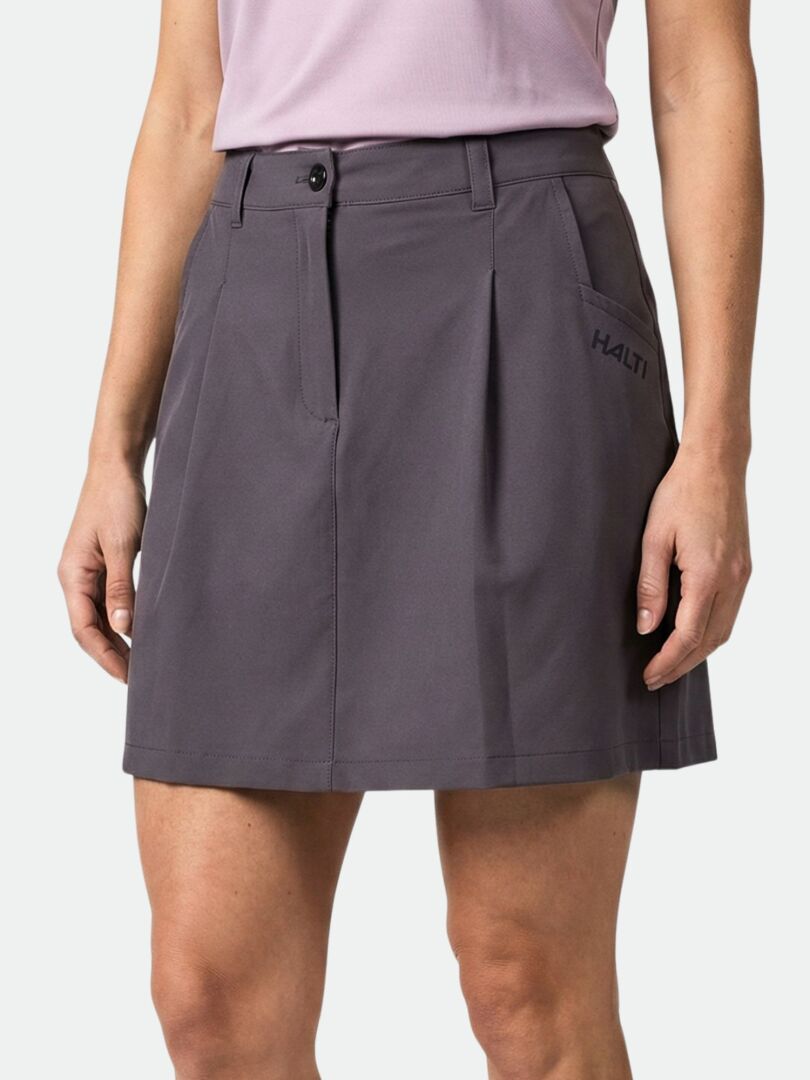A person wears a gray Halti Drive X-stretch Skort Women's with pockets and button closure, paired with a light purple top.