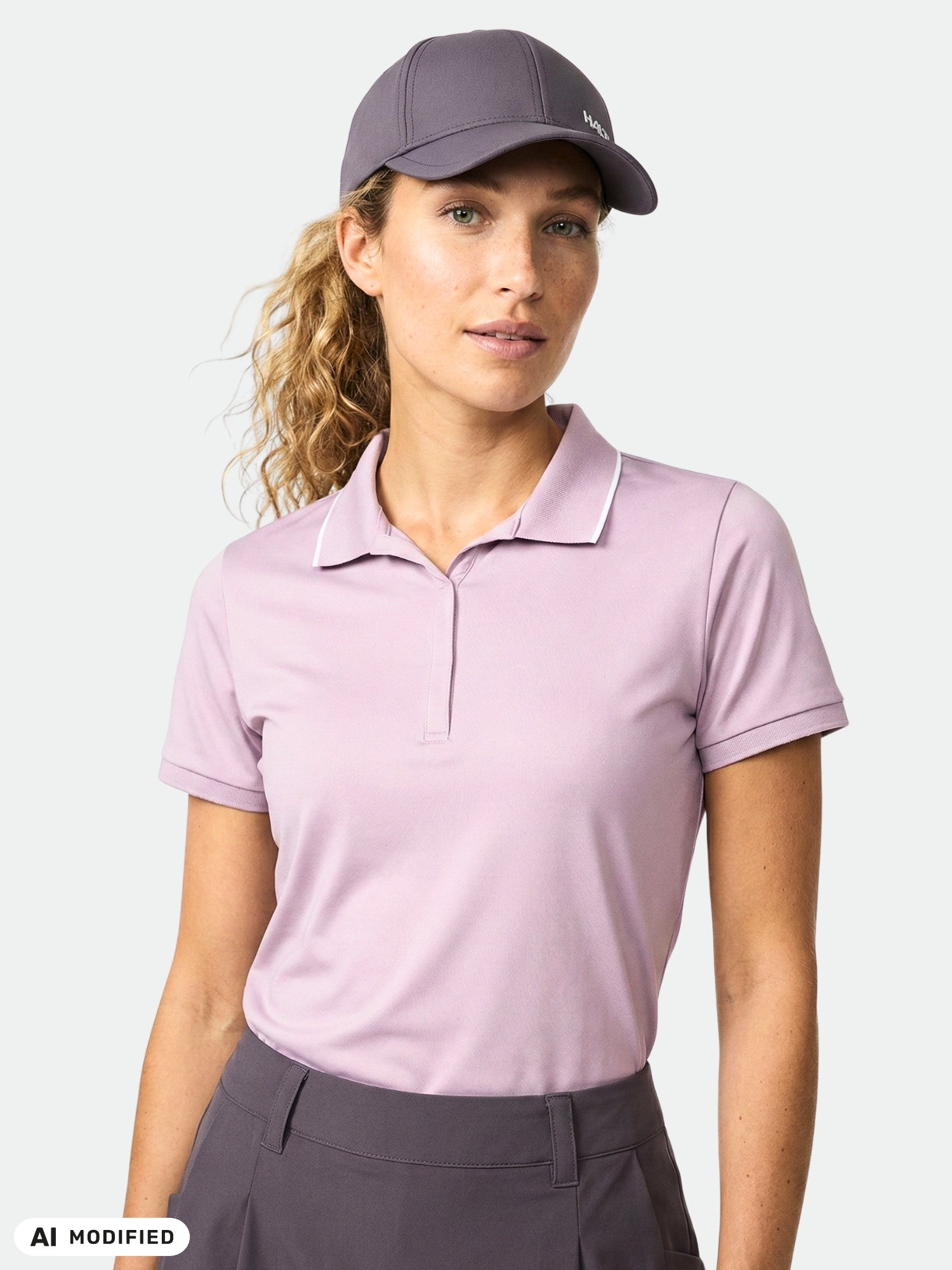 Woman wearing the Halti Swingi Technical Polo Shirt, made from recycled polyester, stands against a plain background.