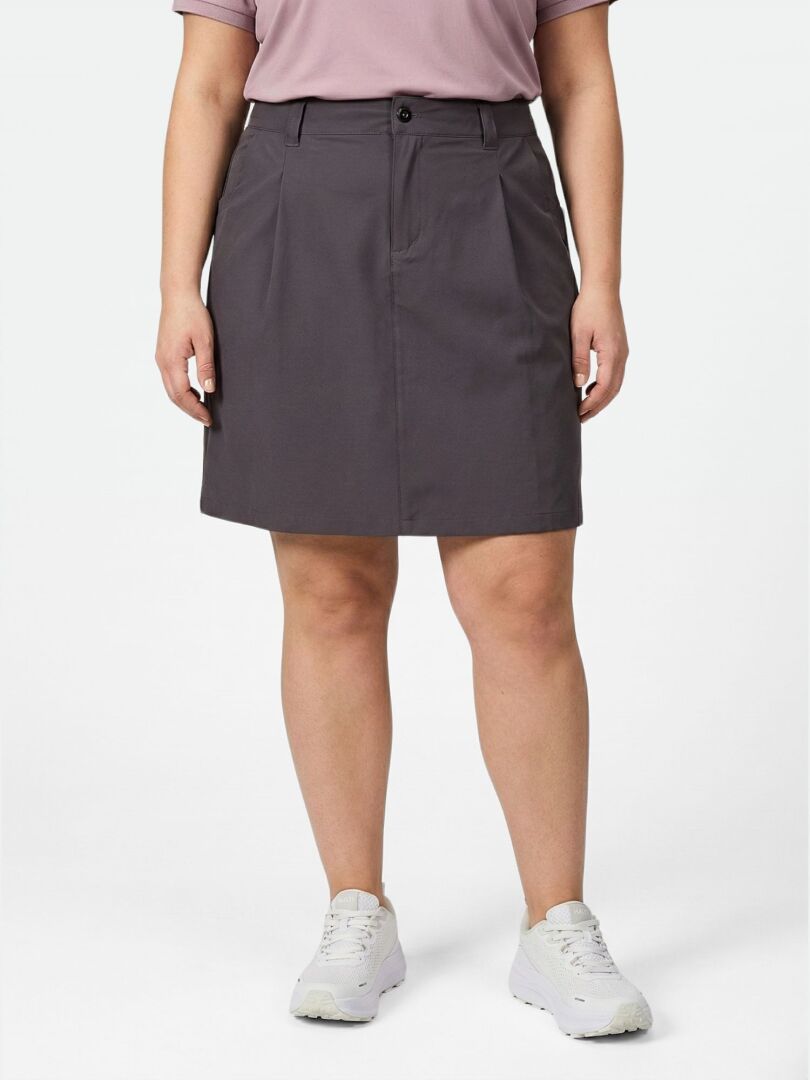 A person in a mauve shirt and Halti Drive X-stretch Skort Women's Plus with white sneakers stands against a white background.