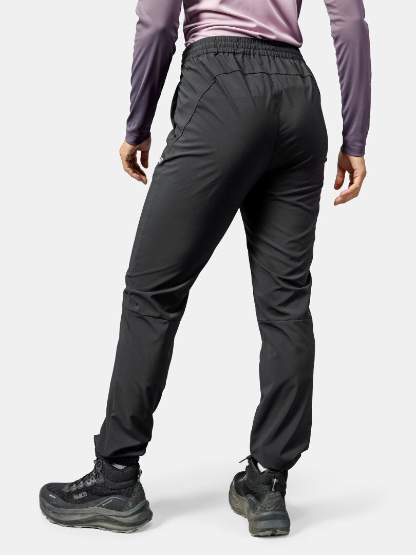 A person is shown from the back wearing Halti Grets Jogger Pants for women, a purple long-sleeve top, and black sneakers.