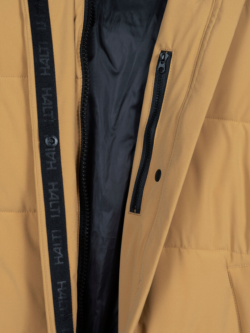 Close-up of Halti Brahe Puffer Long Winter Jacket showing tan color, black vertical zipper, and dark inner lining.