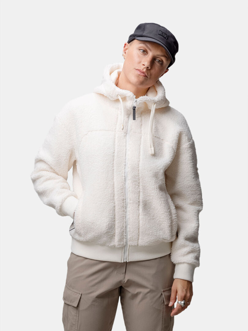 Model wears the Halti Lykky Fleece Jacket Womens, beige cargo pants, and a black cap against a plain background.