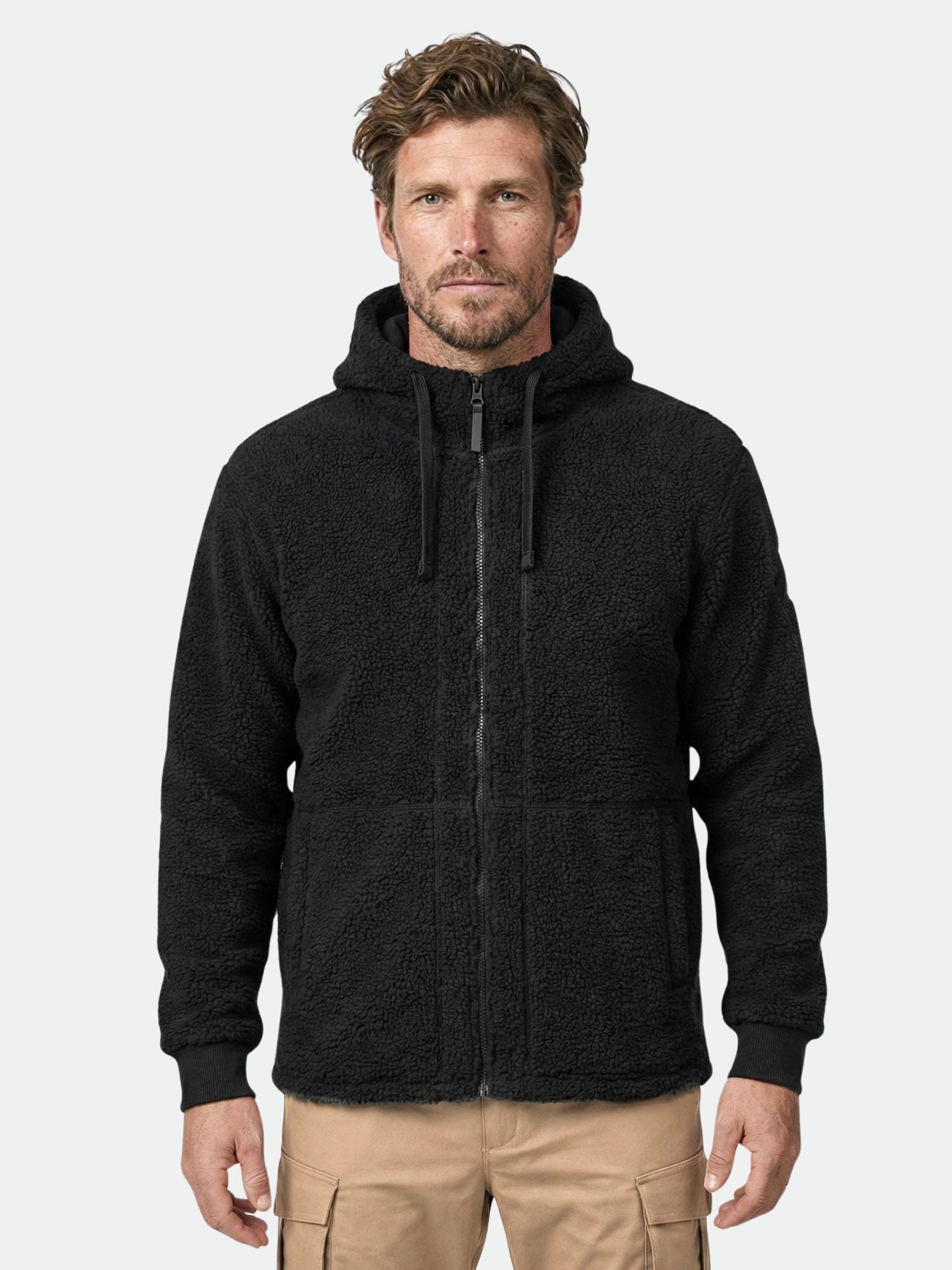 Man wearing a Halti Lykky Fleece Jacket Men's, a hoodie-style recycled fleece, and tan cargo pants.