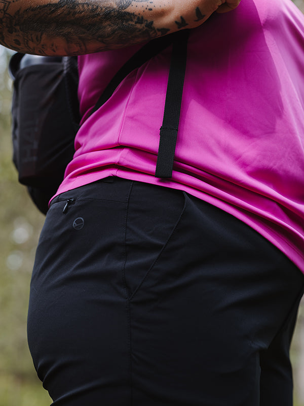 Close-up of a person outdoors in a pink shirt and Halti Drive X-stretch Womens Plus Capri Pants with UPF 50+, strap over shoulder.