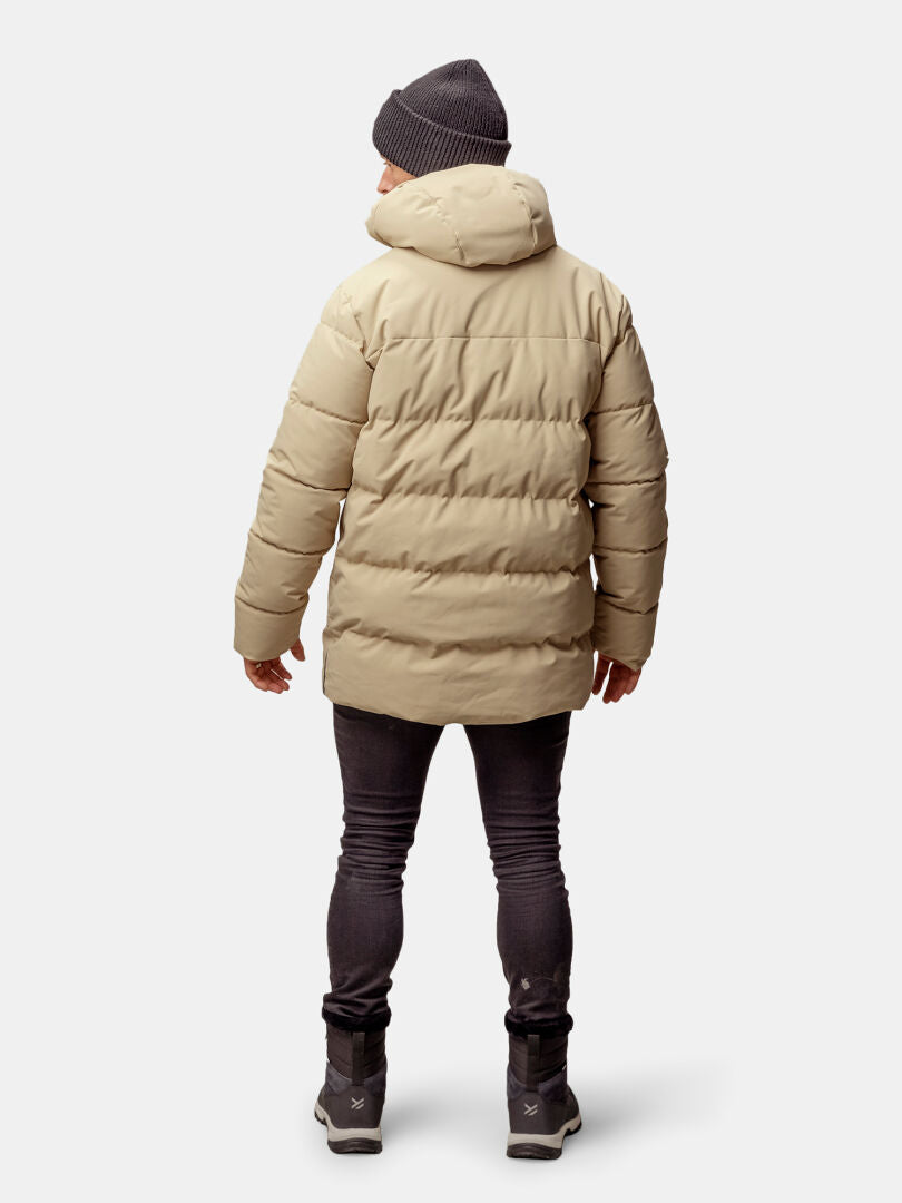 A person in a Halti Sammal Insulated Parka Jacket for men stands facing away, wearing black jeans and a knit hat.