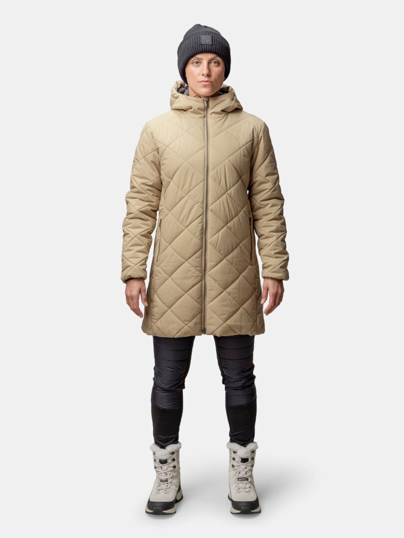 Person wears the Halti Haapa Quilted Coat Jacket for women, black pants, gray beanie, and winter boots against a plain background.