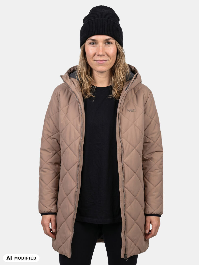 Model in Halti Haapa Quilted Coat Jacket and black beanie stands against a plain light background.