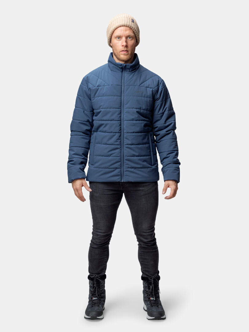 Man wearing Halti Haapa Insulated Jacket for men, black jeans, boots, and a beige knit beanie facing forward.