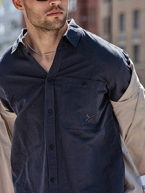 Man wearing Halti Notsgi Longsleeve Shirt Men's with beige sleeves, silver chain, and sunglasses outdoors.
