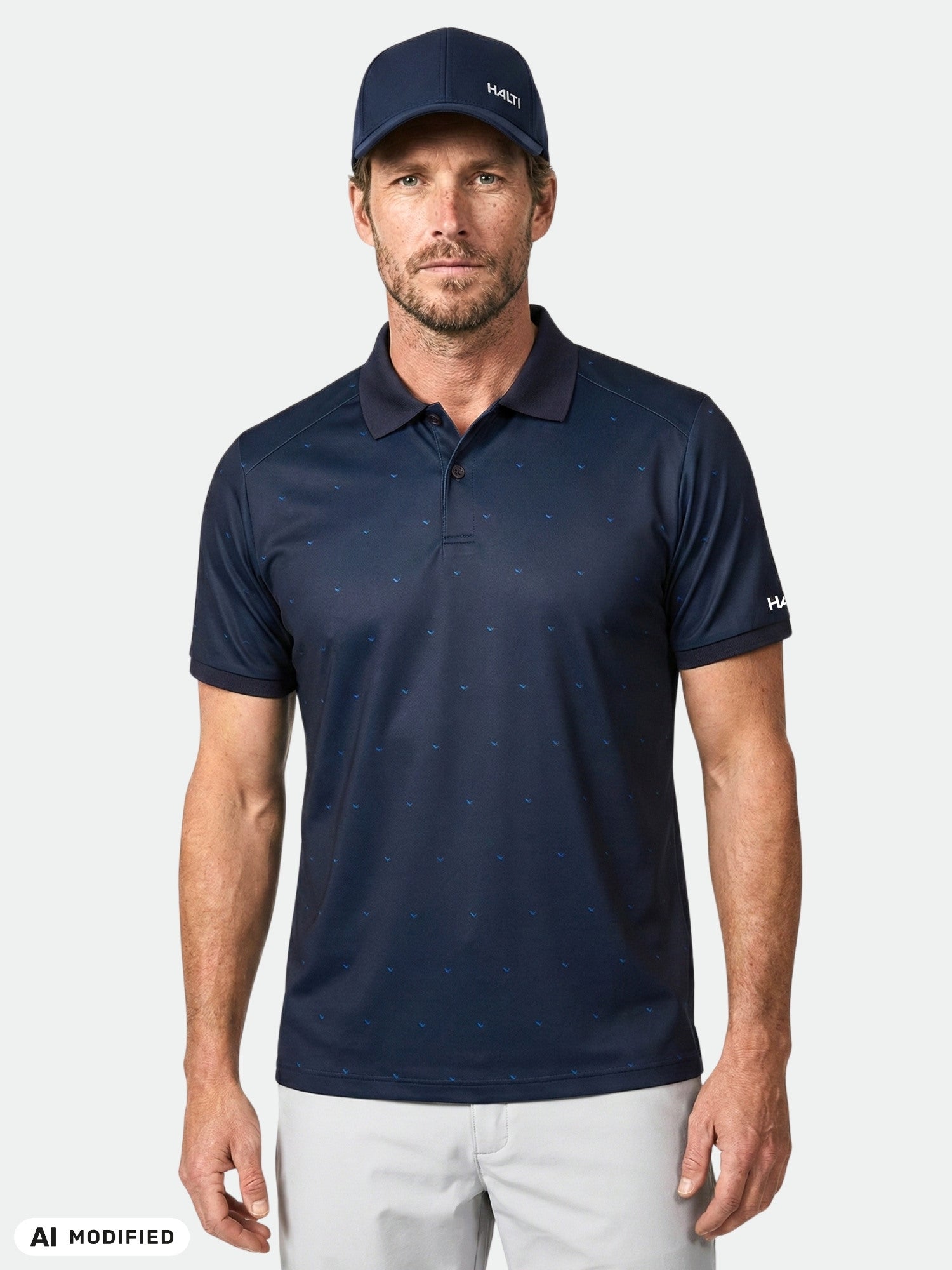 Man in Halti Aridi Technical Polo Shirt, light gray pants, and a navy cap.