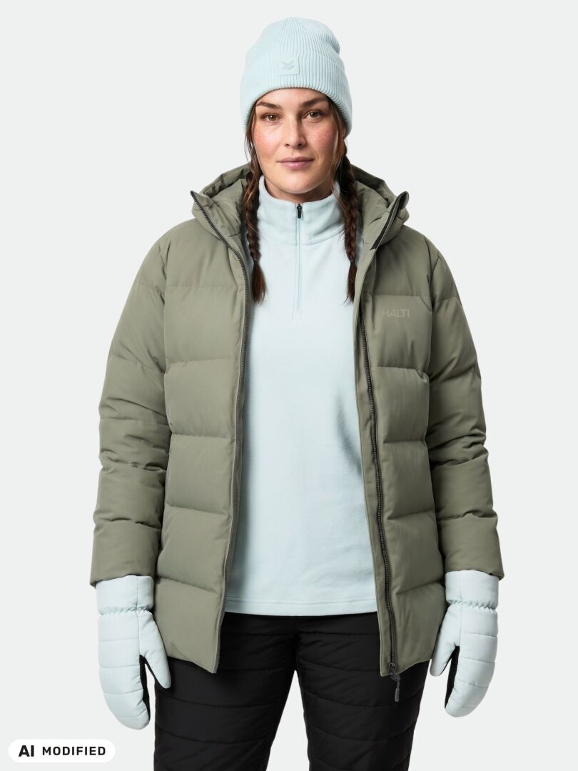 A woman wearing the Halti Leinikko Puffer Parka Women’s Plus and a blue beanie stands facing forward.