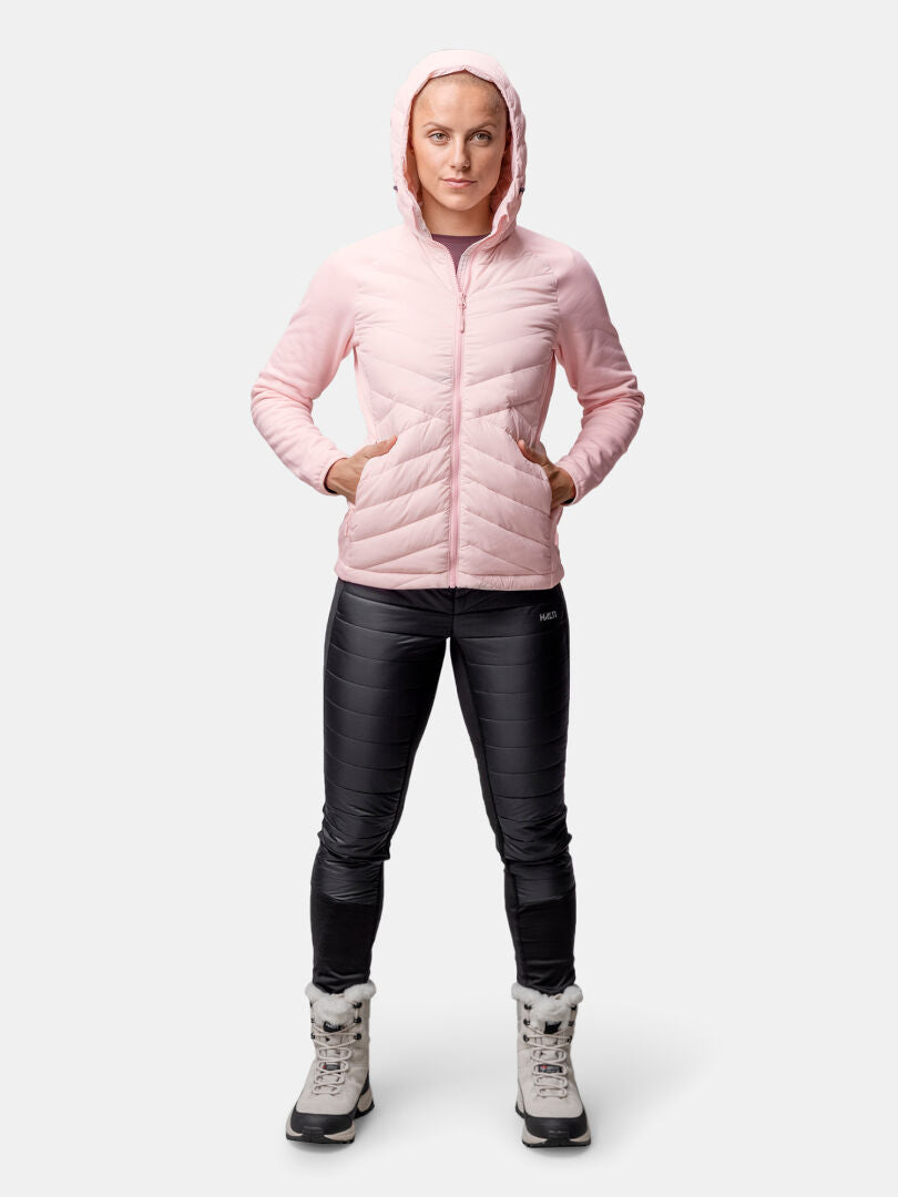 A person stands facing forward in the Halti Huippu Hybrid Down Jacket Womens, black pants, and gray winter boots.