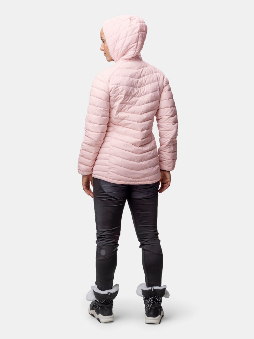 Person wearing a light pink Halti Huippu Mid Down Jacket for women, dark pants, and winter boots, standing facing away.