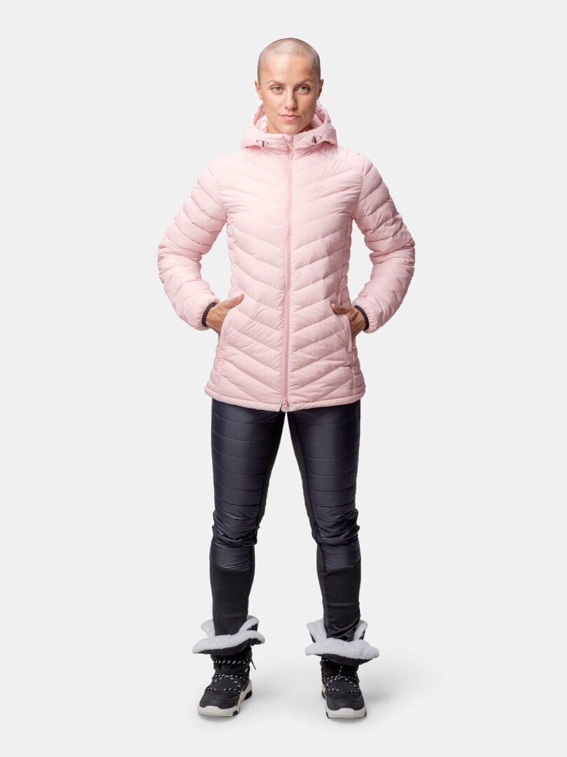 Woman in a pink Halti Huippu Mid Down Jacket, black pants, and black boots with gray accents.