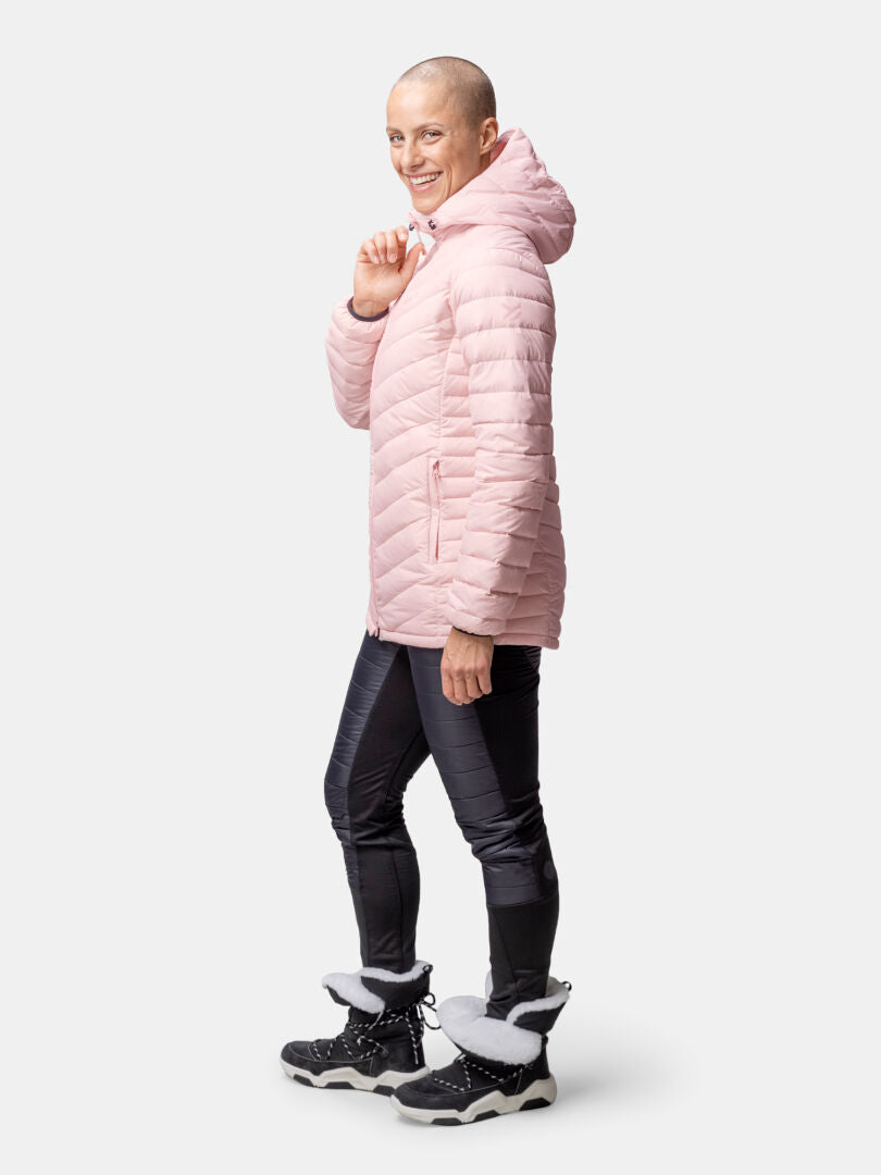 Person wearing a Halti Huippu Mid Down Jacket for women, black leggings, and fur-trimmed boots, smiling.