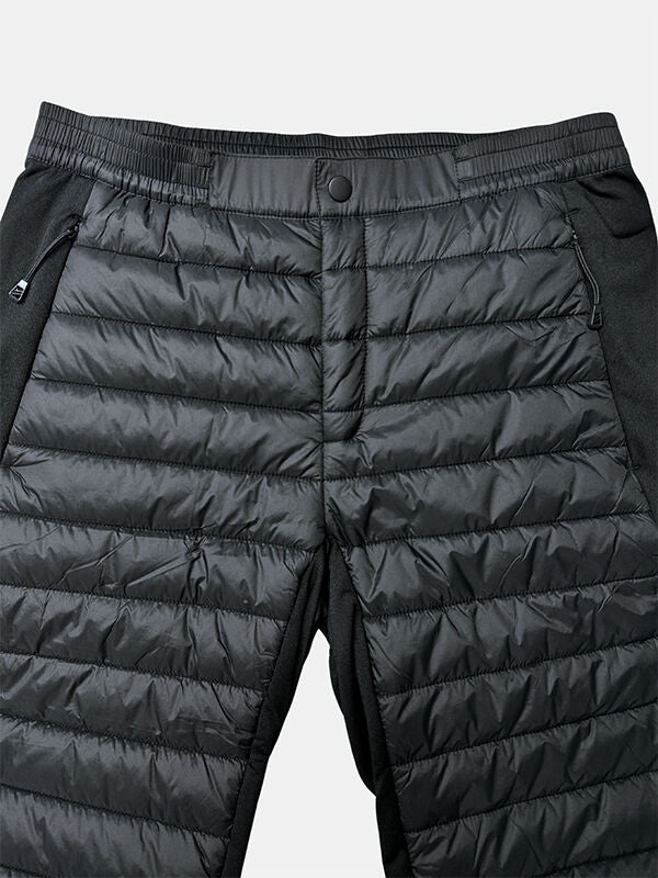 Close-up of Halti Veidnes Insulation Pants Womens Plus in black with snap buttons and zippered pockets on a plain background.