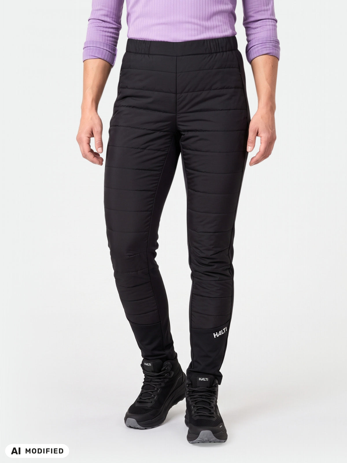 Person in a long-sleeve purple top and black Halti Valimo Hybrid Insulation Pants Women’s, against a plain background.