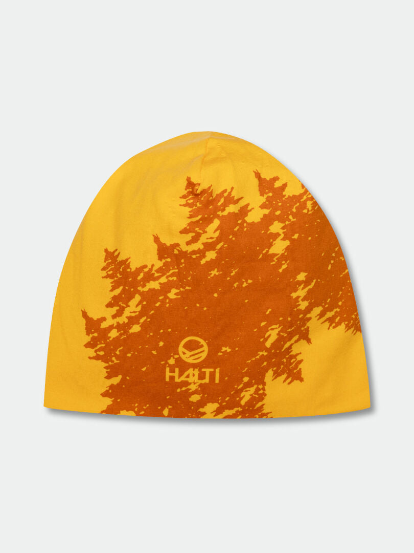 The Halti Laava Beanie is yellow with an orange tree pattern and HAUTI logo, ideal for outdoor adventures.