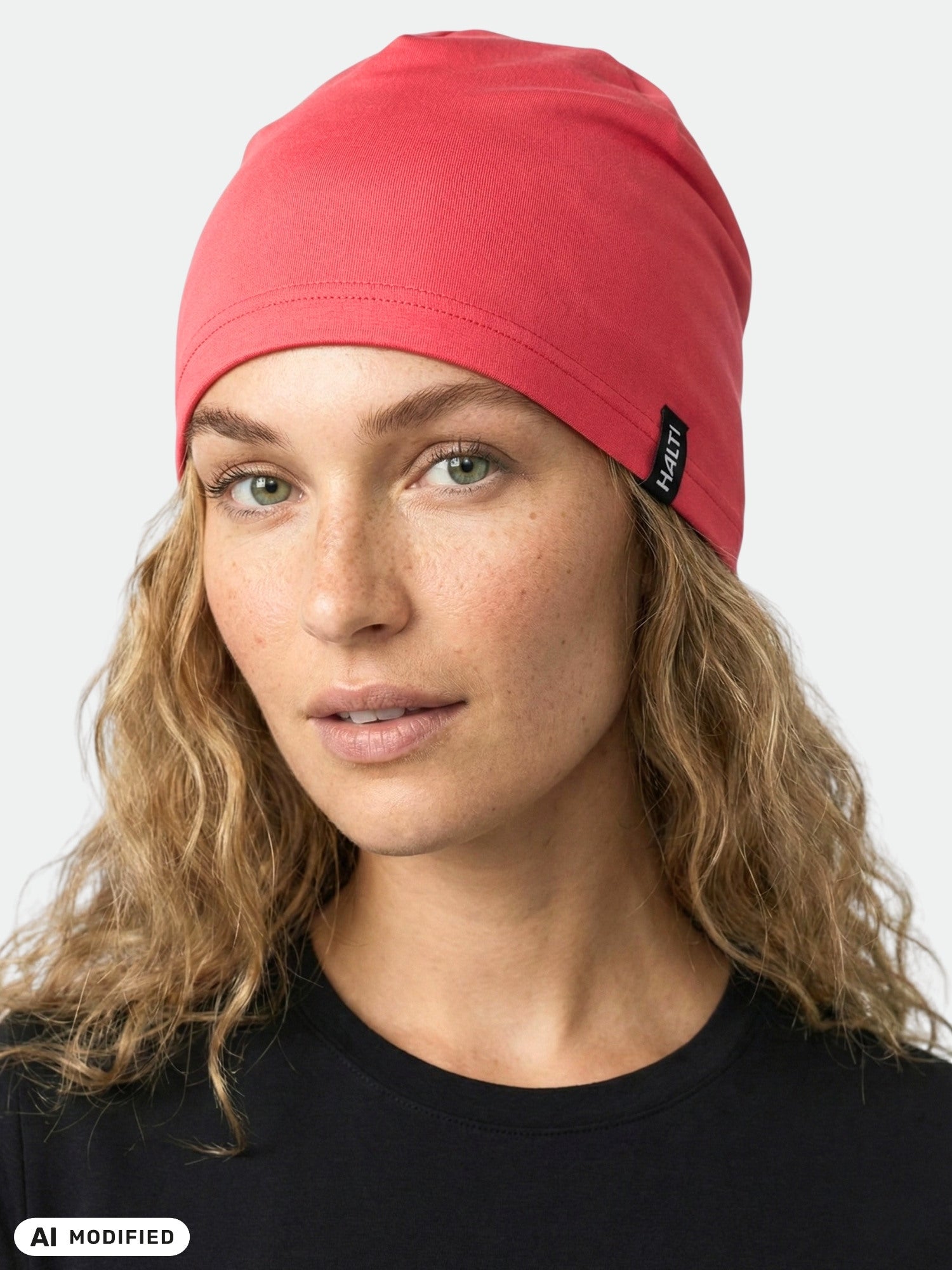 A person with wavy blonde hair wears the Halti Loiva Beanie and a black shirt, facing the camera against a plain background.