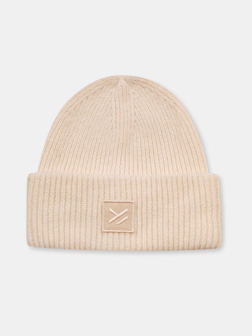 Halti Huurre Beanie: beige chunky rib knit style with folded brim and logo patch, made from recycled polyester.
