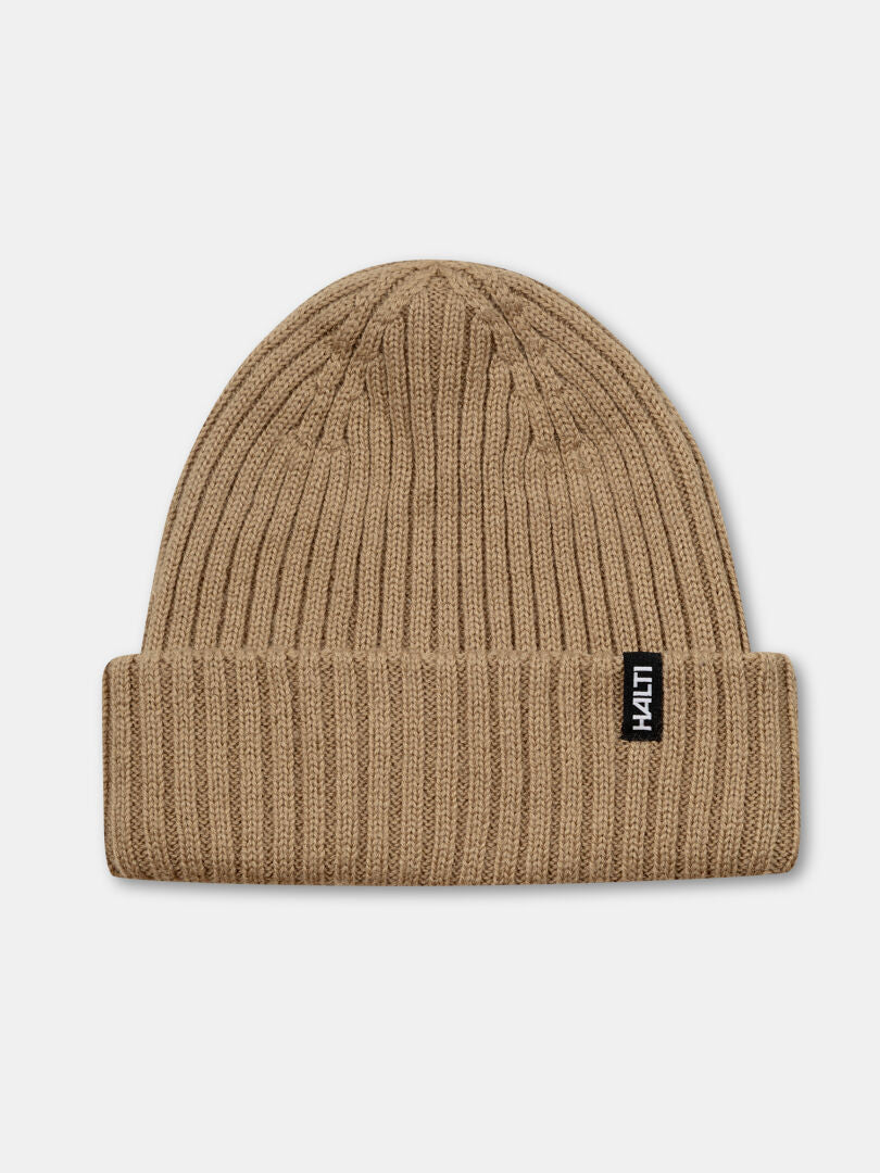 The Halti Runko Beanie is a rib-knit, light brown fisherman hat with a folded brim and black Halti label on the front.