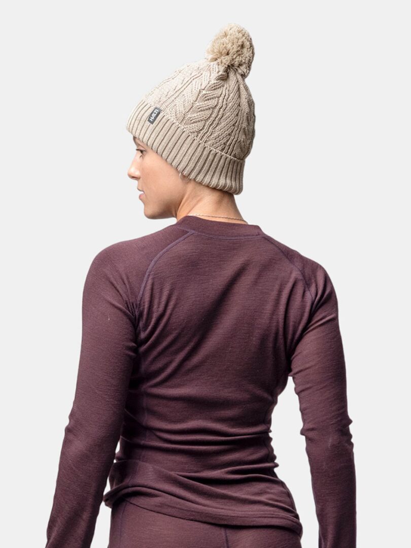 A person wears the Halti Hile Beanie in beige and a maroon long-sleeve shirt, shown from the back.