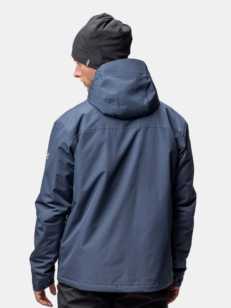 A person in a blue hooded jacket wears the Halti Trone Fleece Beanie, shown from behind against a plain background.