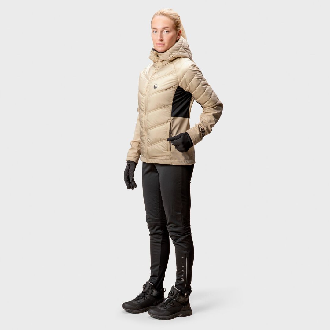 A woman wears the Halti Hanki XCT Jacket in tan, with black pants and gloves—ready for winter running.