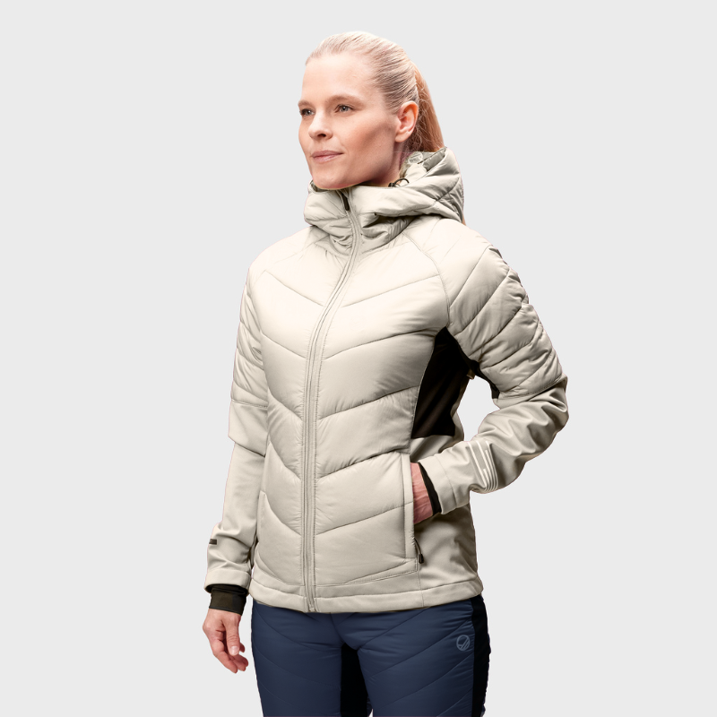 A woman wears the Halti Hanki XCT Jacket and dark pants, standing facing forward against a plain light background.