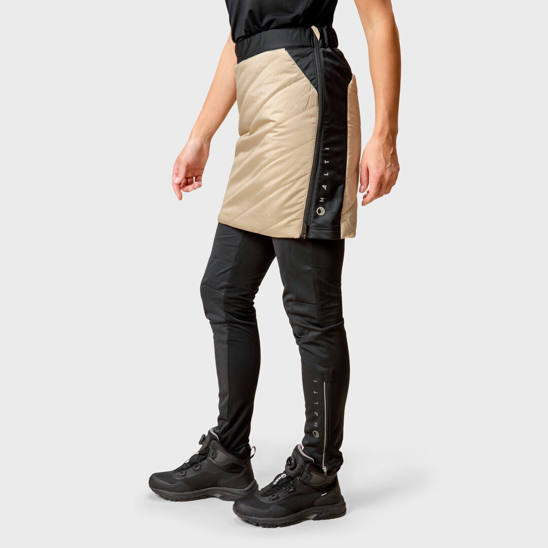Person in black pants, boots, and the Halti Hanki Warm Hybrid Skirt—ideal winter wear for staying active.