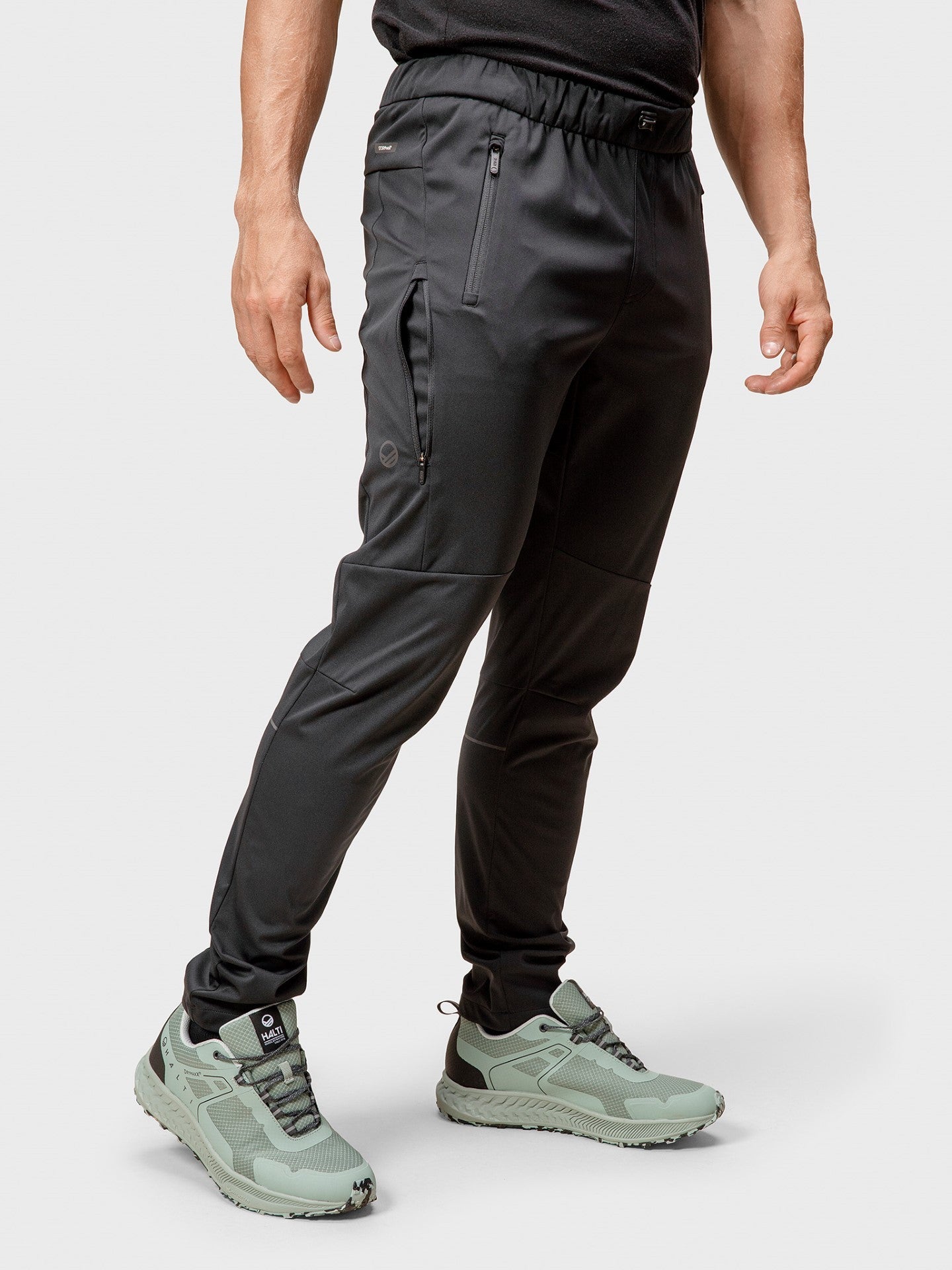 A person in Halti Exhale Stormwall Pants stands against a plain light background.