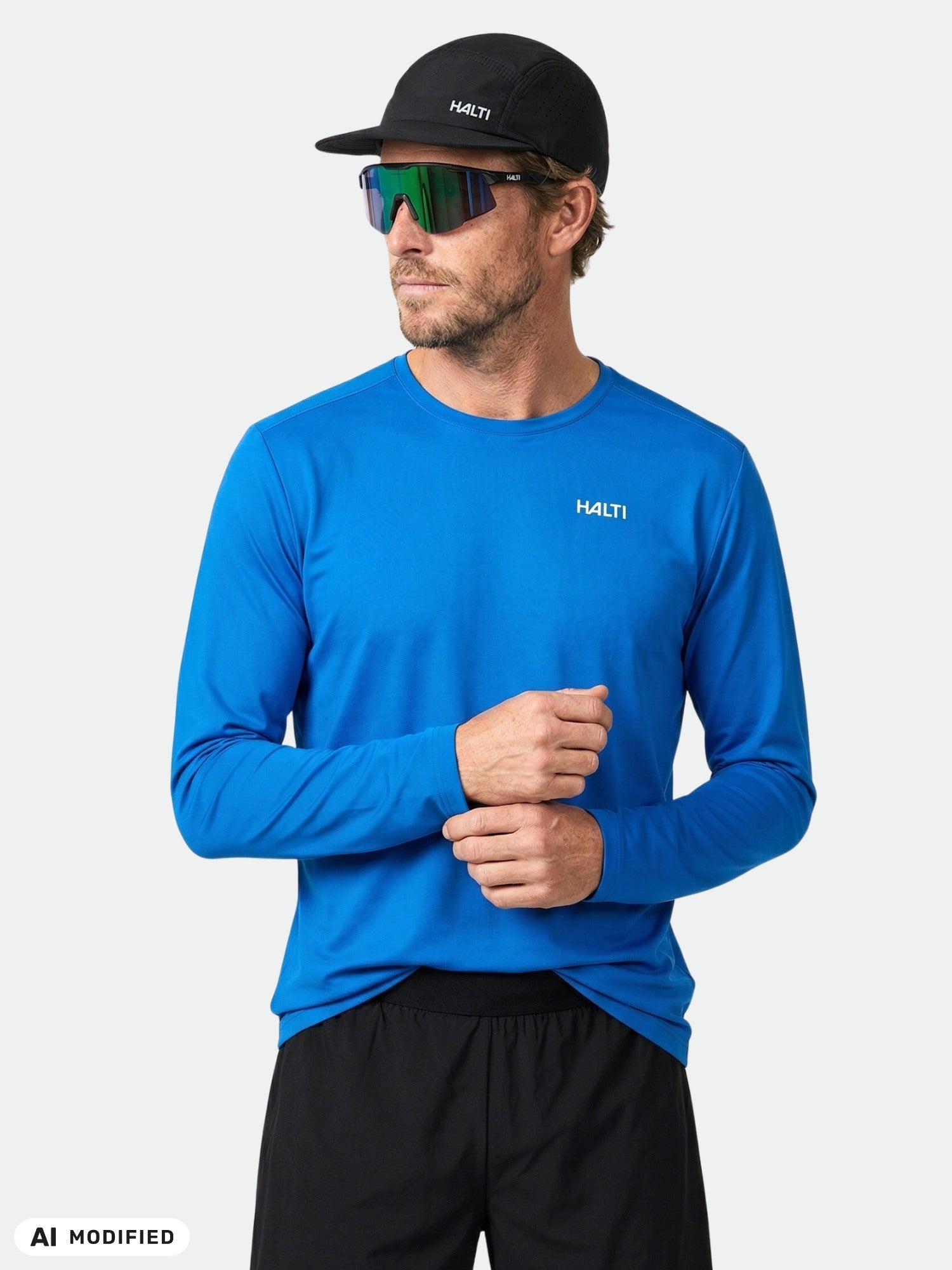Man in Halti Salves Training Shirt, black cap, and sunglasses stands against a plain background, facing slightly right.