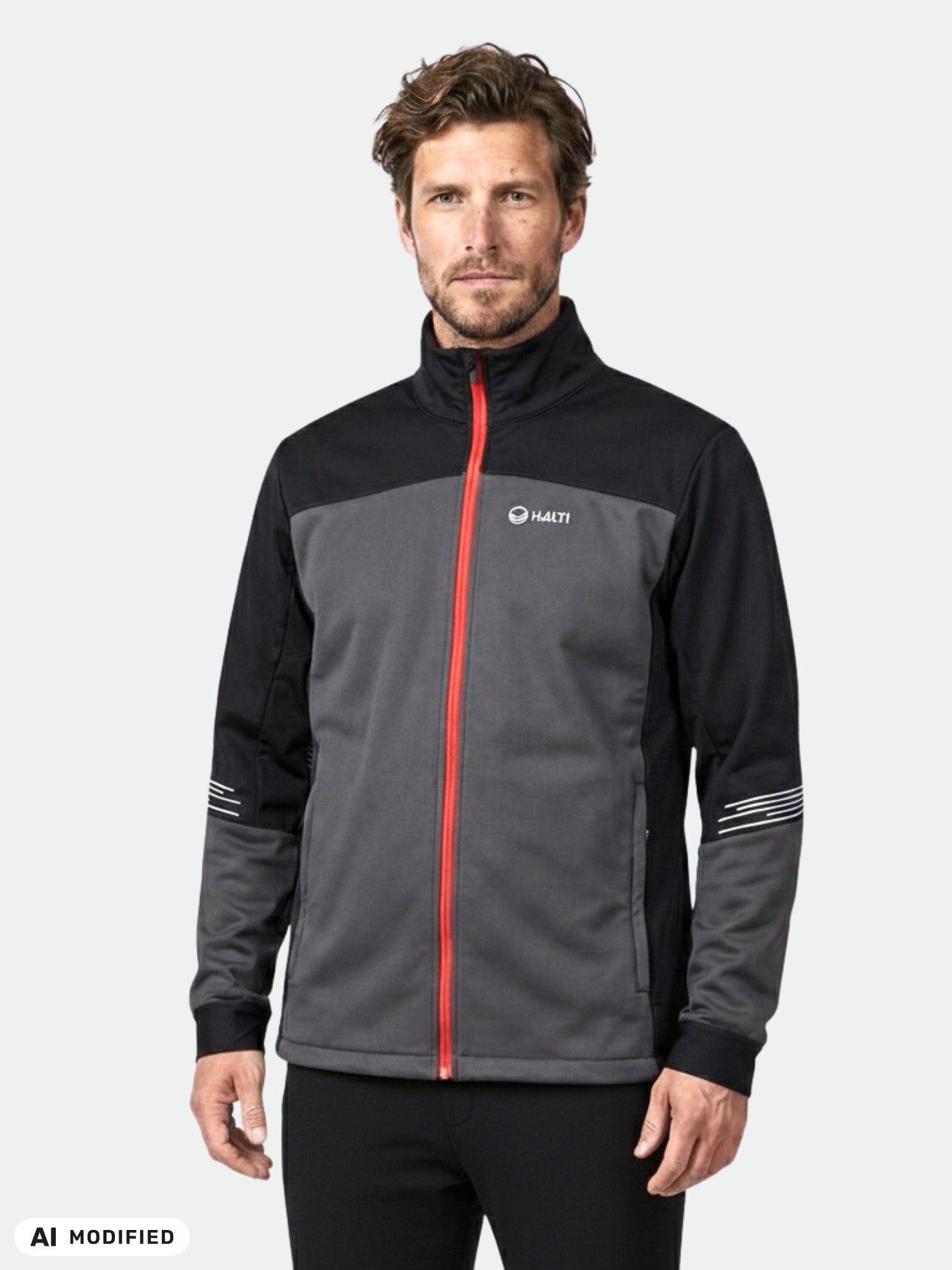 Man in Halti Siide XCT Set Men's black/gray ski jacket with red zipper & reflective stripes, on plain background.
