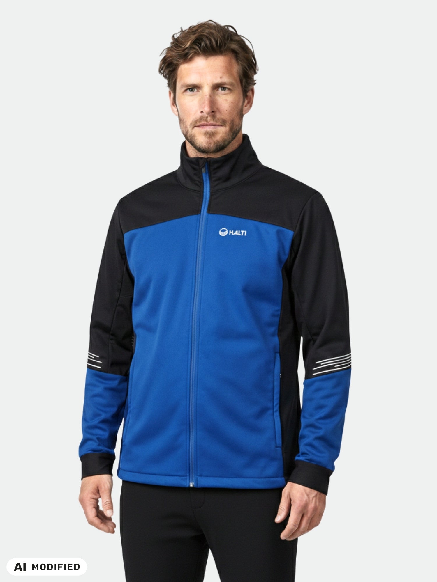 Man in Halti Siide XCT Set Men's blue and black ski suit against a plain light background.
