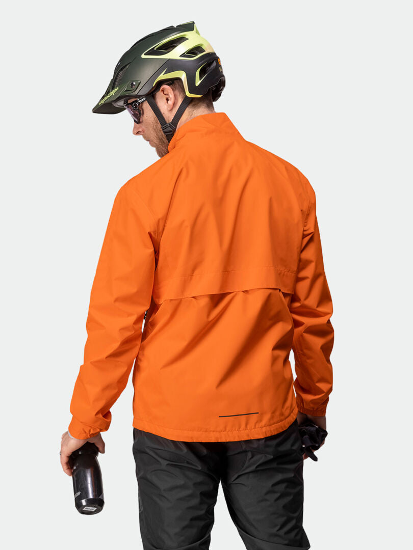 A man wears the Halti Triant DX Cycling Jacket, with reflective details, holding a water bottle, seen from the back.