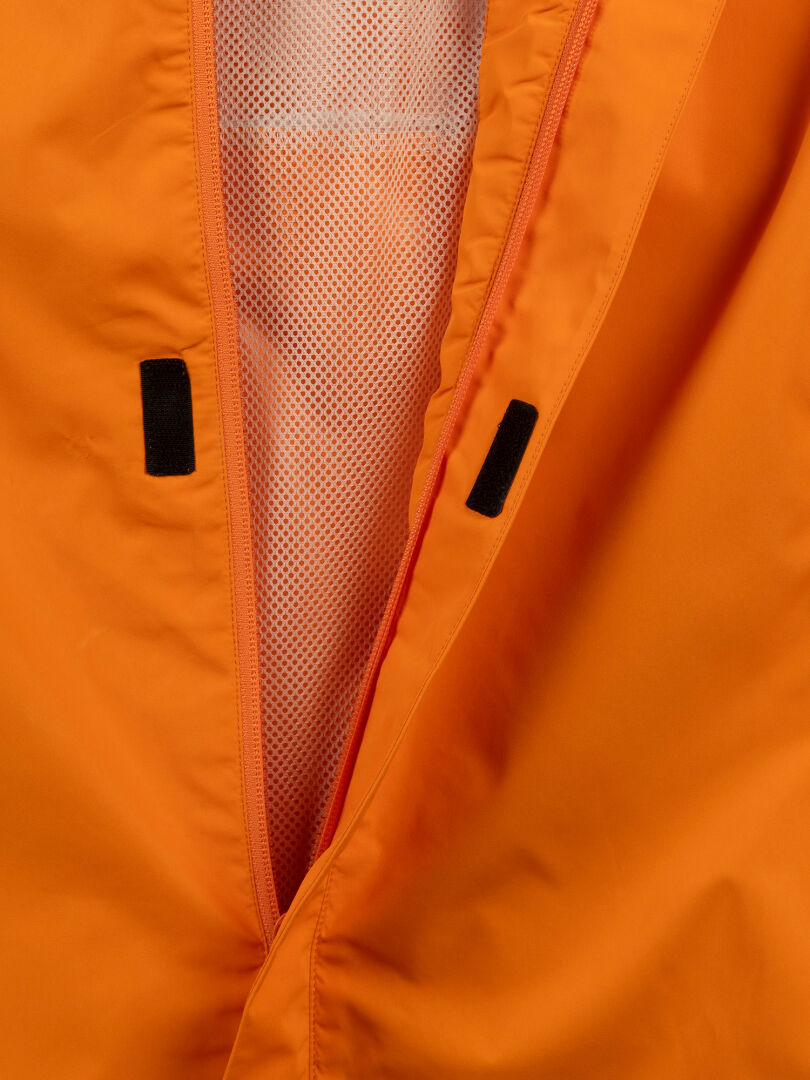 Close-up of Halti Triant DX Cycling Jacket Mens: orange with reflective details, white mesh lining, and black tabs inside.