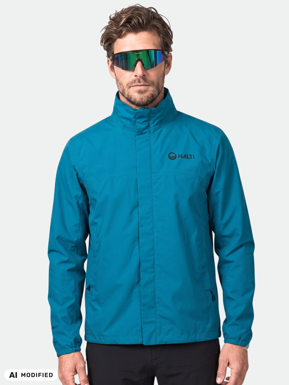 A man wears a Halti Triant DX Cycling Jacket in teal with reflective accents, facing forward on a white background.